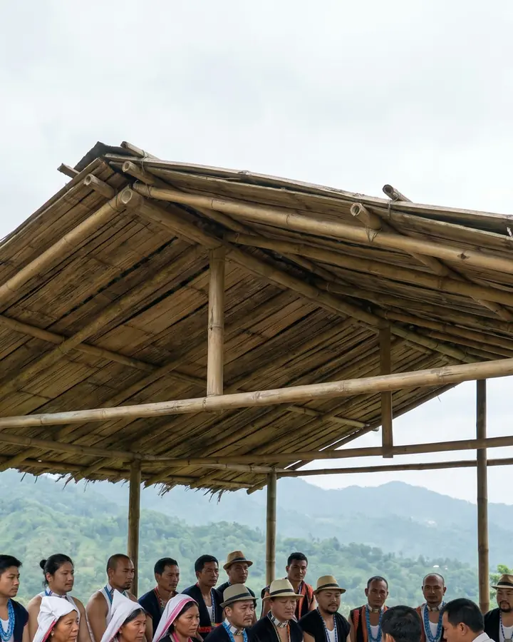 Adi villagers in traditional dress seated at a village consultation under a bamboo shelter; callout 2–3 years, with the timeline bar.